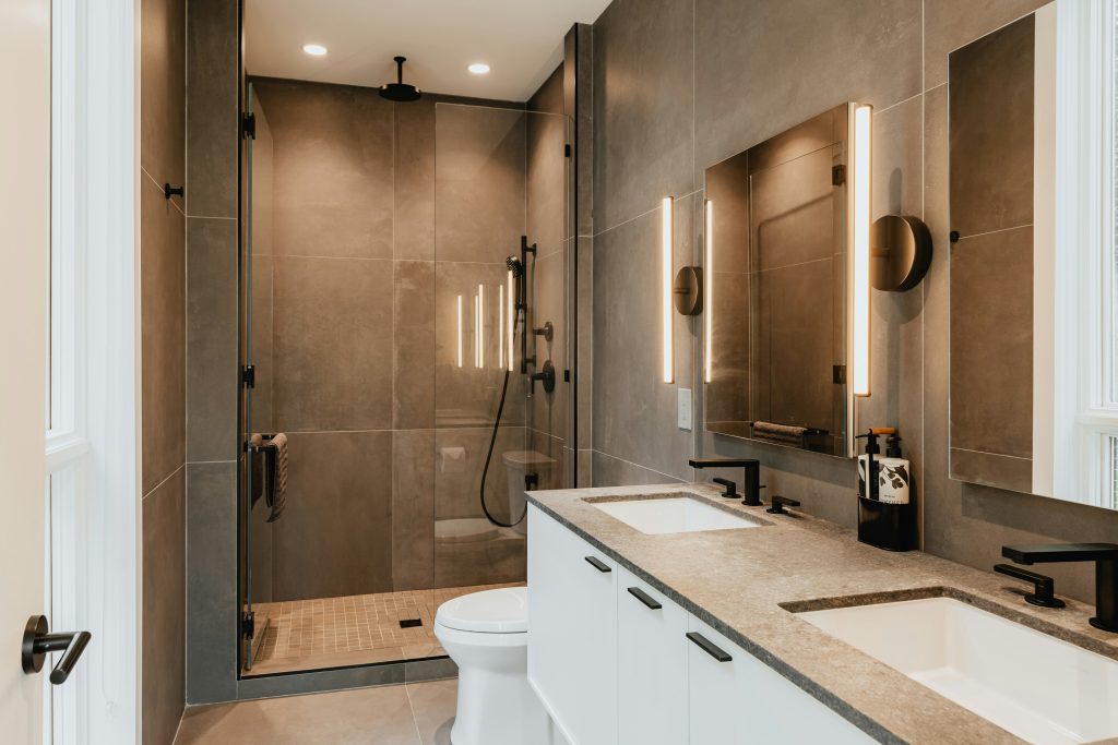 Modern bathroom remodeling in Cary, NC featuring a frameless glass shower, double vanity, premium tile, and contemporary finishes by SkyRise Remodeling.
